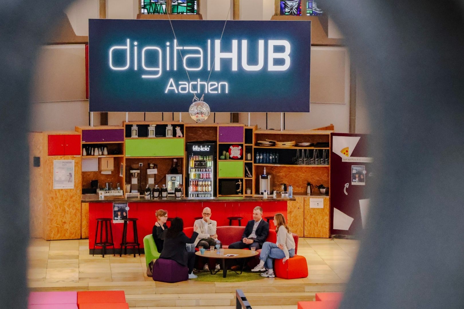 Vertreter der Unternehmen Lancom und Netaachen sitzen zusammen mit der Geschäftsführerin des diditalHUB Aachen in der digitalCHURCH vor dem digitalHUB Aachen Logo an einem Tisch Vertreter der Unternehmen Lancom und Netaachen sitzen zusammen mit der Geschäftsführerin des diditalHUB Aachen in der digitalCHURCH vor dem digitalHUB Aachen Logo an einem Tisch